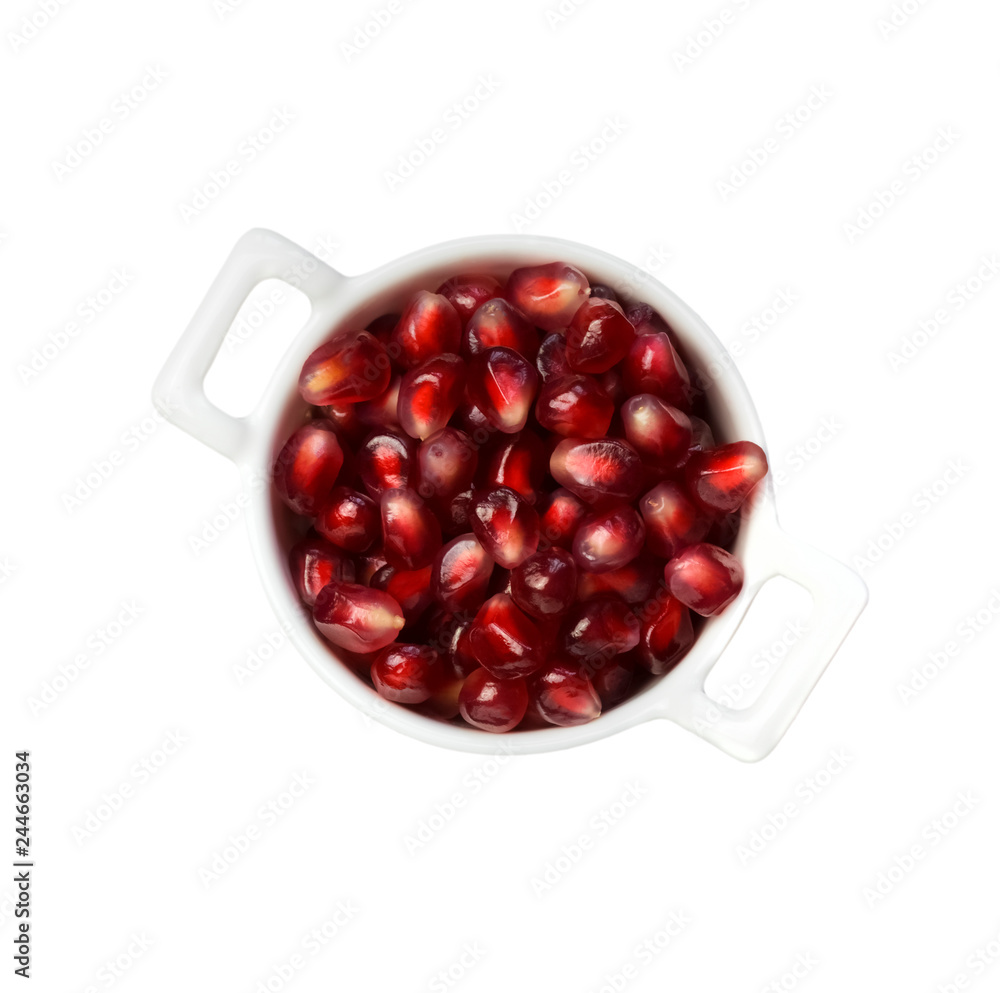 Pomegranate seeds in the white bowl isolated in white. Pomegranate seeds in the white bowl isolated in white.