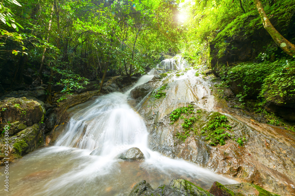 Beautiful waterfall in deep forest and soft water of the stream in the natural park, Thailand.