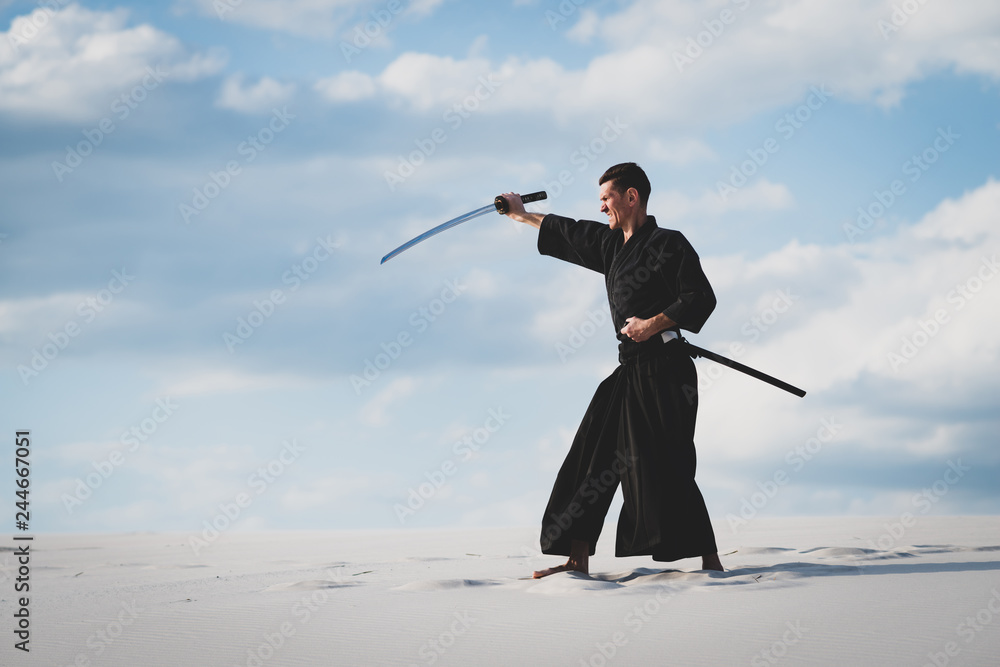 Man training martial arts in desert