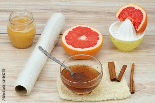 Cellulite treatment from honey, cinnamon and grapefruit juice. Ingredients for homemade anti cellulite wrap on the table