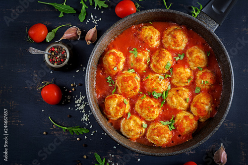 Chicken meatballs with tomato sauce in a pan. Dinner. Top view. Dark background.