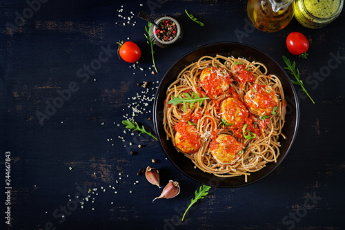 Italian pasta. Spaghetti with meatballs and parmesan cheese in black plate on dark rustic wood background. Dinner. Top view. Slow food concept