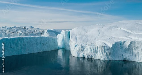 Iceberg aerial drone video- giant icebergs in Disko Bay on greenland floating in Ilulissat icefjord from melting glacier Sermeq Kujalleq Glacier Affected by Global warming and climate change.