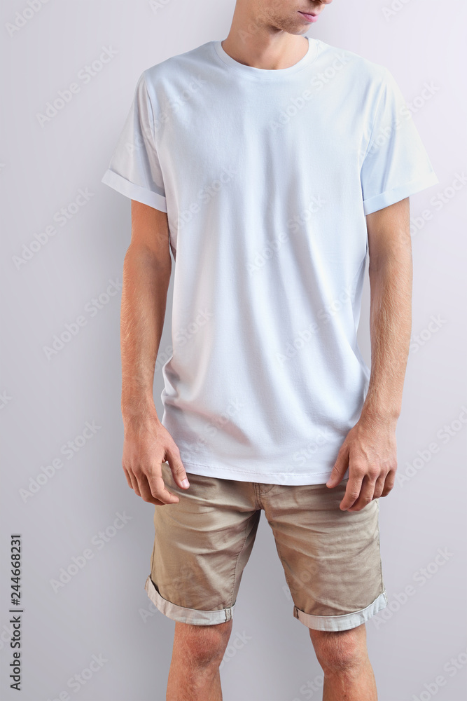 Obraz premium Stylish slim guy in a blank T-shirt on a white studio background.