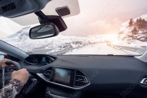 Hand holding steering wheel in luxury private car, Driving in rural road on winter