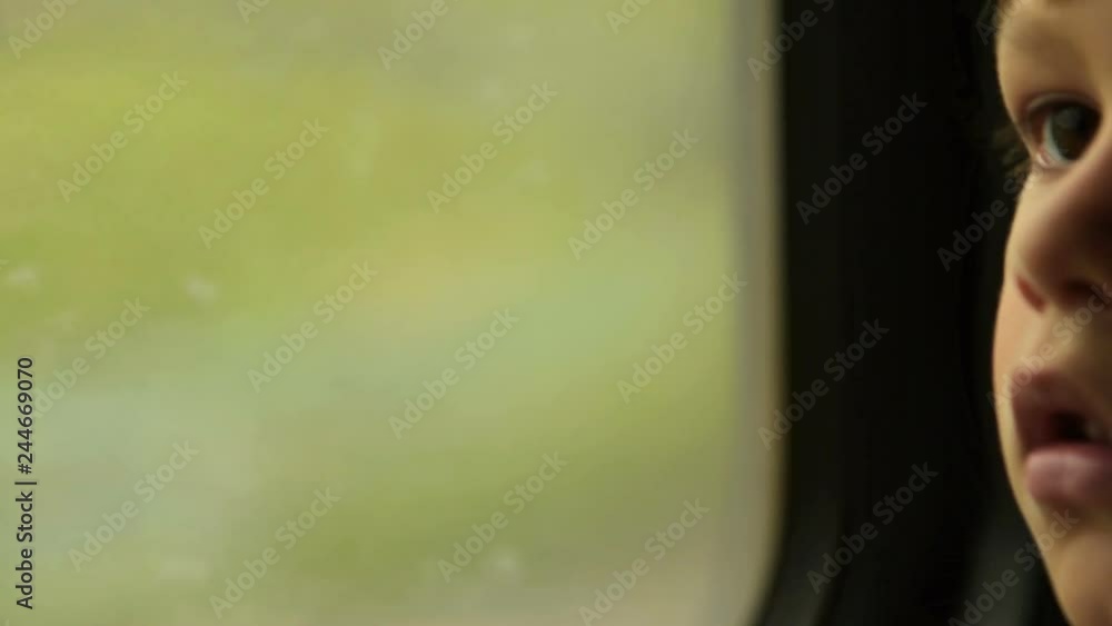 Child traveling by train and looking through the through the window Child traveling by train and looking through the through the window