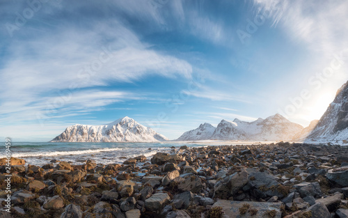 Panorama of snow mountain range with rocks in arctic ocean on winter