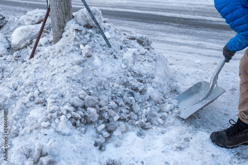 Man clearing snow with shovel on wayside