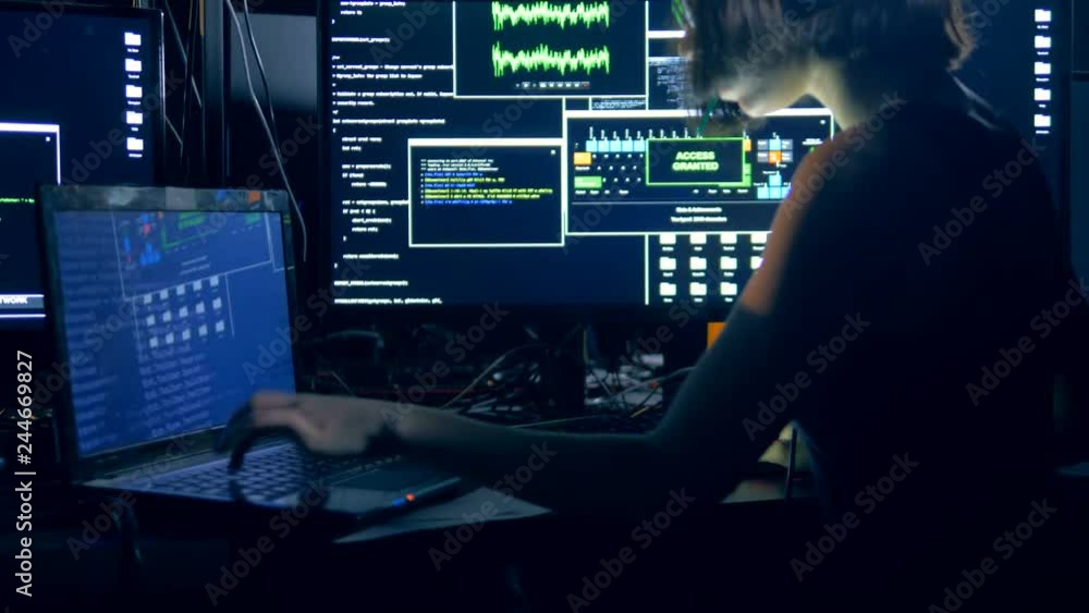 Laptop and computers are being used by a young woman for hacking