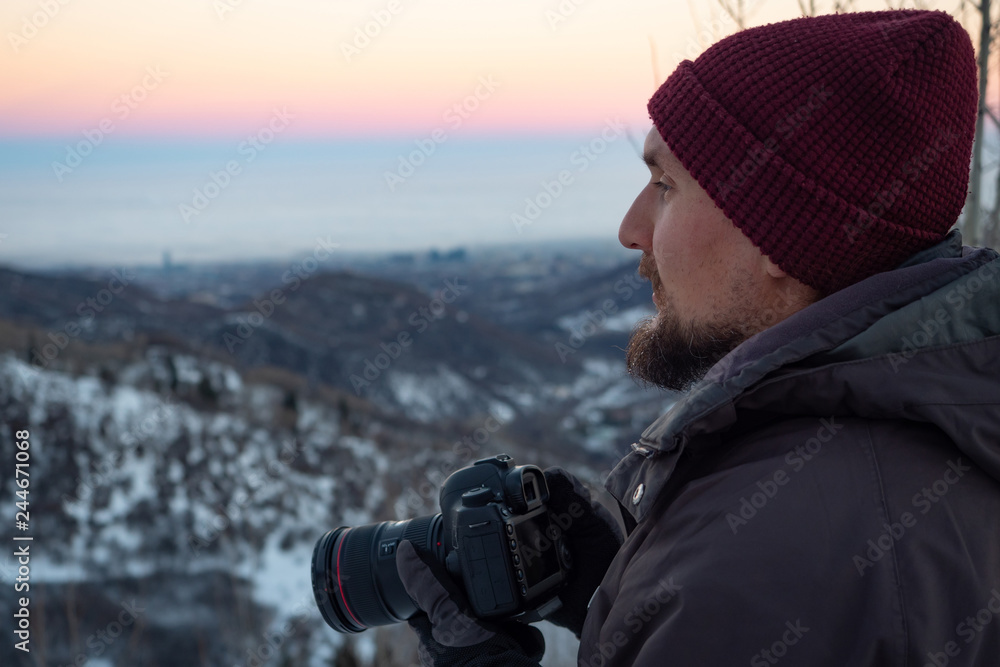 The guy with the camera, early in the morning in the winter in the mountains, looking out for the plot