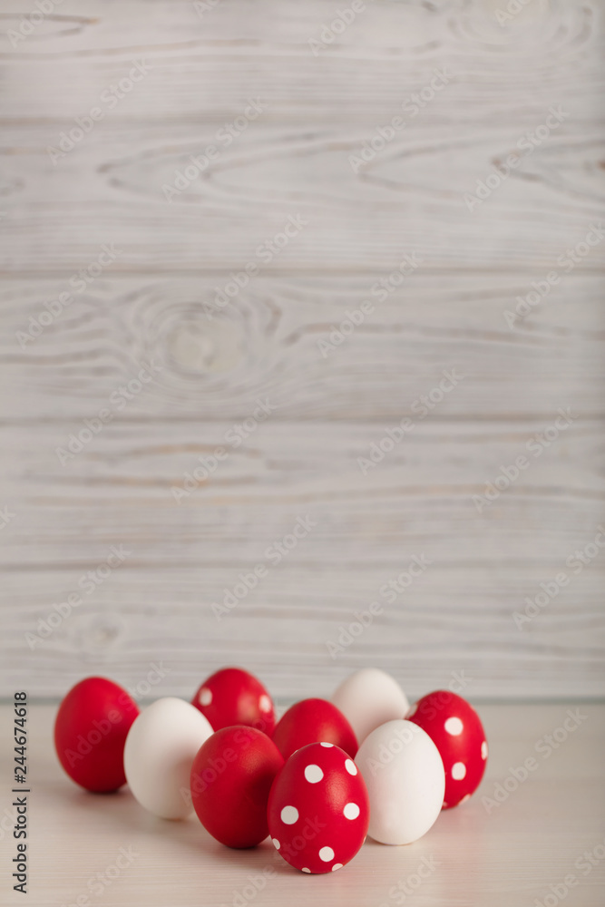 Obraz premium Happy Easter! Painted Easter eggs - red, white and red with white polka dots on a gray wooden background.