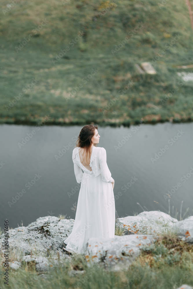Boudoir morning bride in nature in a white dress. Wedding series on cliffs and river bends. Boudoir morning bride in nature in a white dress. Wedding series on cliffs and river bends.