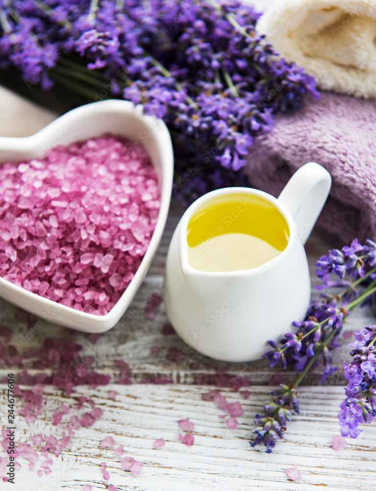 Heart-shaped bowl with sea salt, oils, soap and fresh lavender flowers on a wooden background Heart-shaped bowl with sea salt, oils, soap and fresh lavender flowers on a wooden background