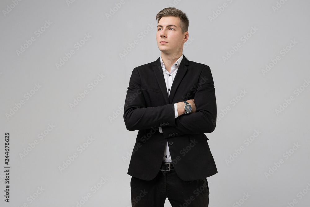 Portrait of young man in black suit with arms crossed isolated on white background Portrait of young man in black suit with arms crossed isolated on white background