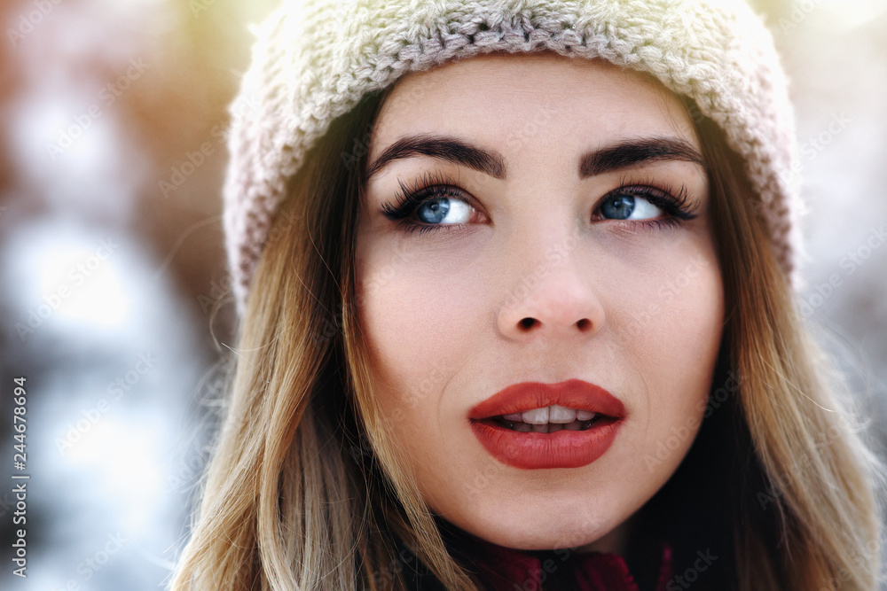 close up portrait of fashion woman with blue eyes and blond hair. Nice red lips and knitted hat. Look aside. winter holiday concept close up portrait of fashion woman with blue eyes and blond hair. Nice red lips and knitted hat. Look aside. winter holiday concept