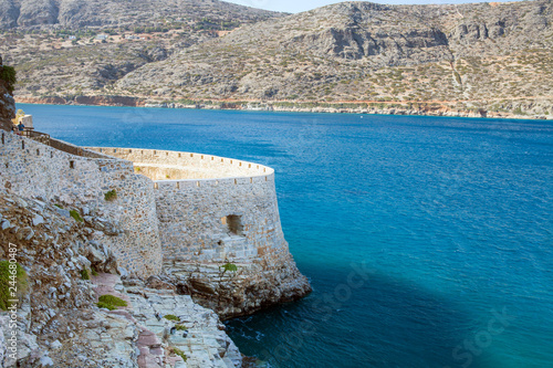 Fragment of a defense tower and walls in the Spinalonga fortress. Sea view from the leper island in Greece.