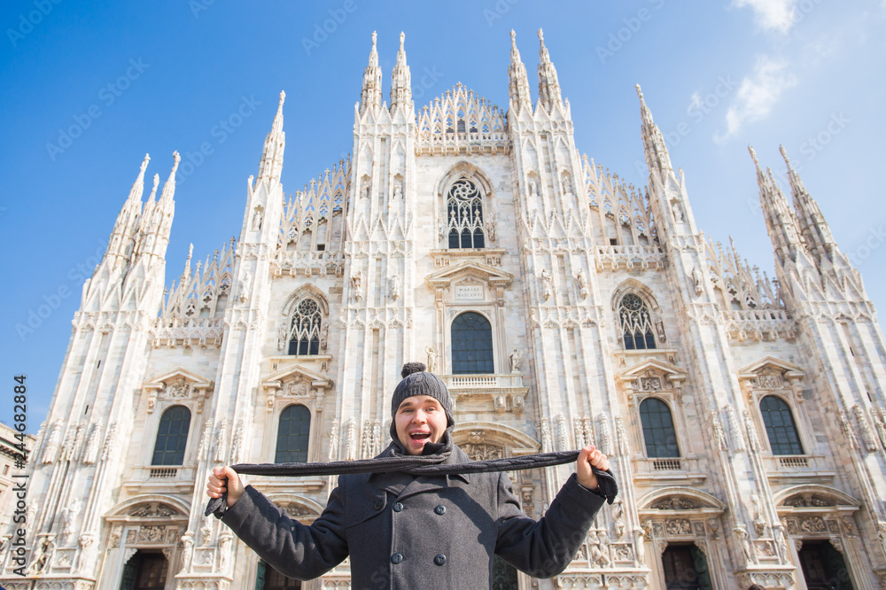 Winter travel, vacations and people concept - Handsome male tourist making selfie photo in front of the famous Duomo cathedral in Milan.