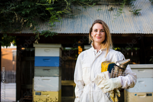 Beekeeper in front of her bee hives