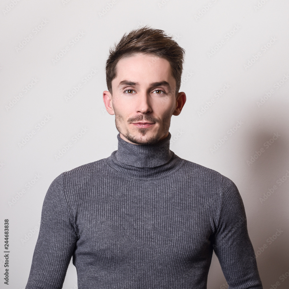 Obraz premium Handsome young elegant man in grey golf.