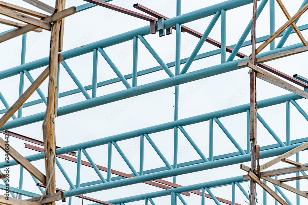 Steel truss structure with wooden scaffolding at construction site. Structural engineering concept