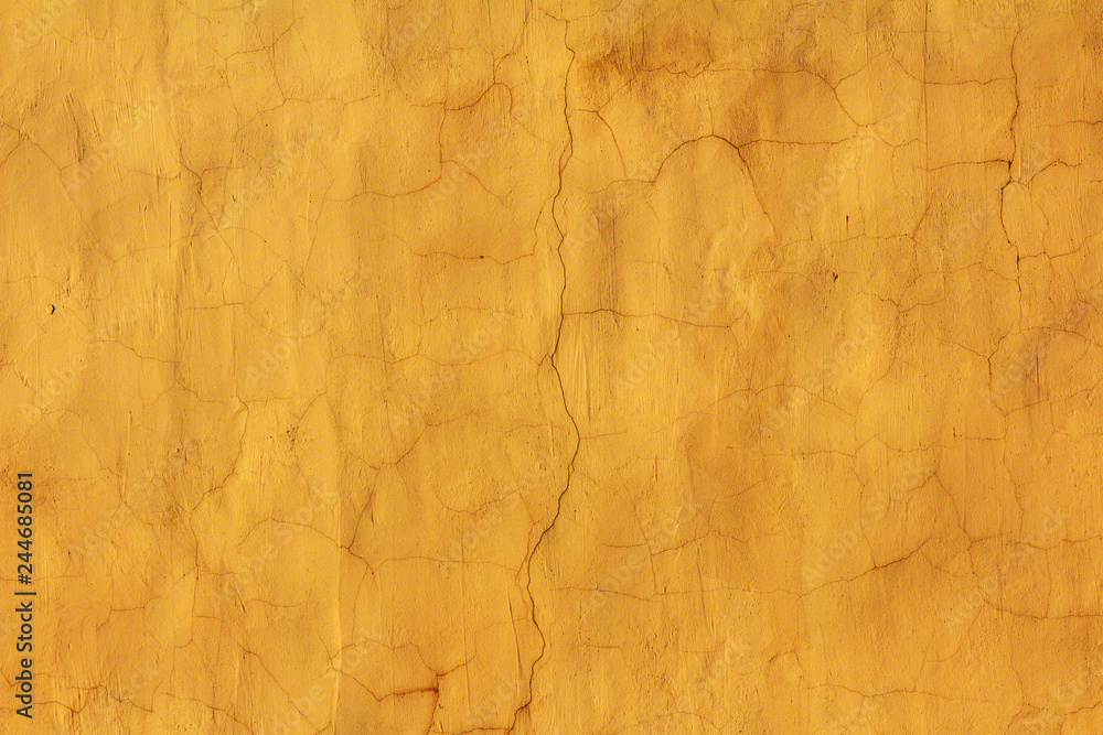 textured bright yellow wall with lots of cracks and scratches