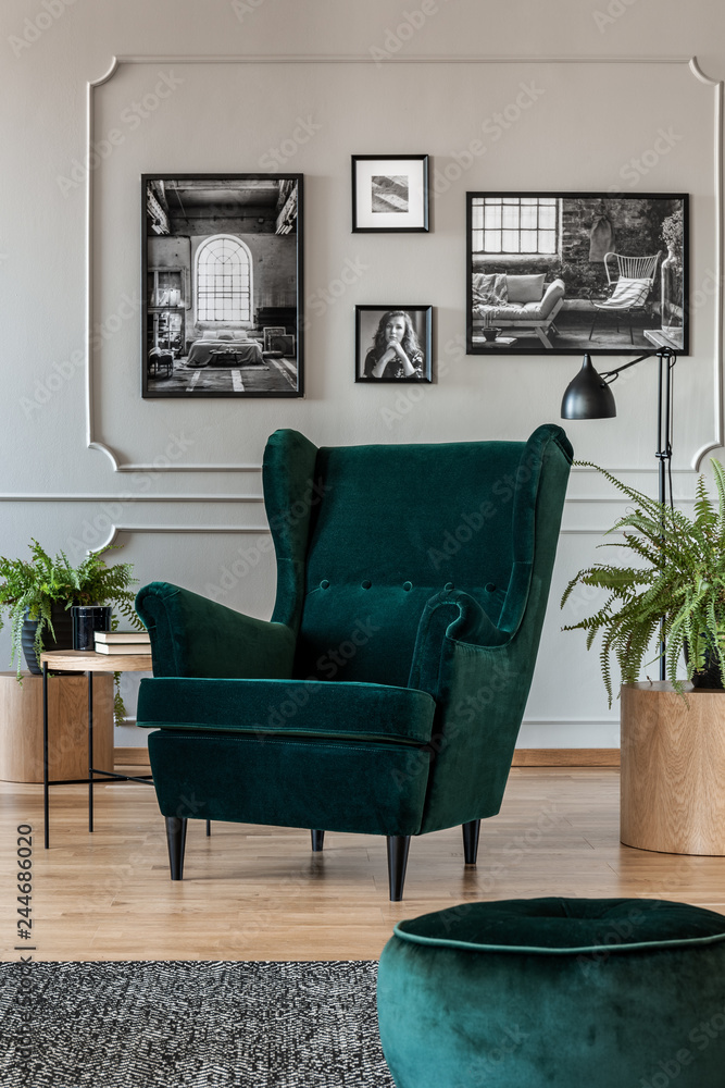 Emerald green armchair and pouf in grey living room interior with wooden  furniture and black and white photos on the wall Stock Photo | Adobe Stock