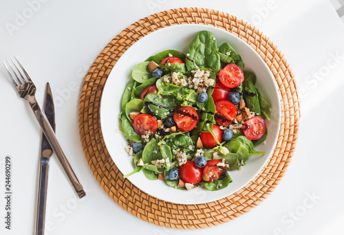 Delicious salad with quinoa, tomatoes and spinach, top view