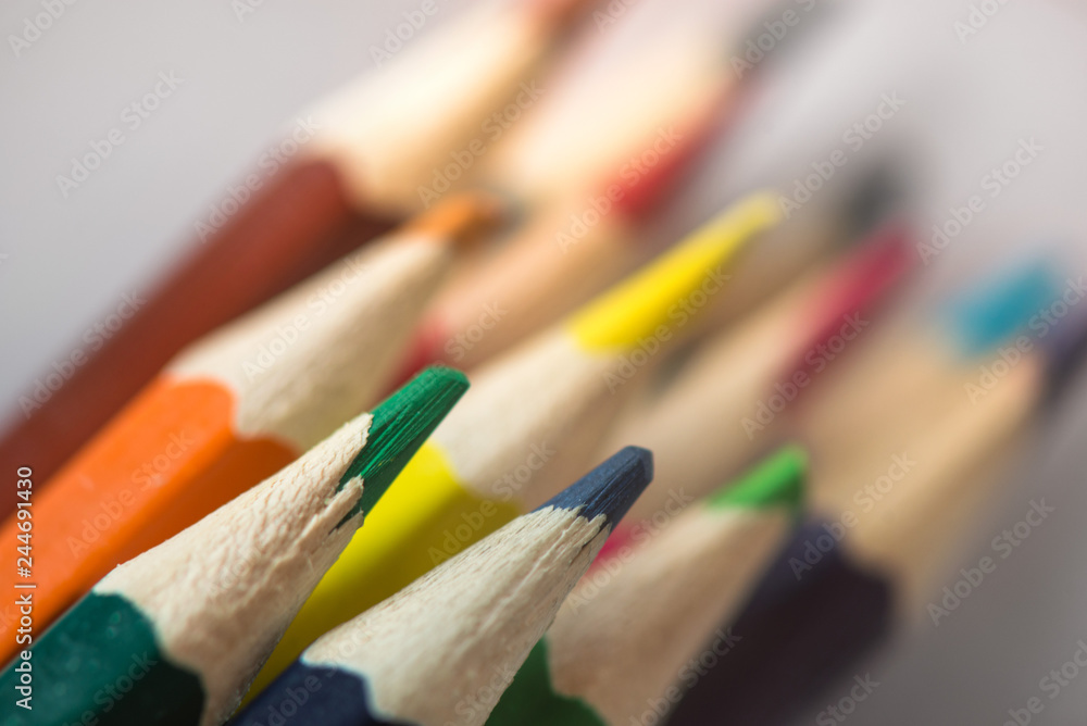 Pile of sharp coloured drawing pencils on table. Rainbow colors red, yellow, blue, green, purple. Concept of art, crafts and kids having fun Pile of sharp coloured drawing pencils on table. Rainbow colors red, yellow, blue, green, purple. Concept of art, crafts and kids having fun