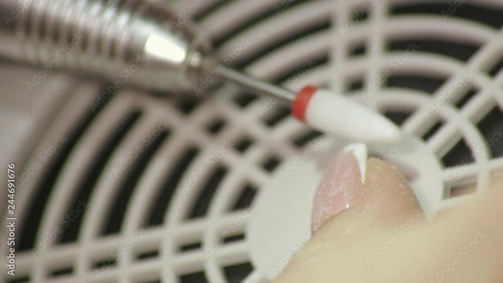 Female manicurist removes old gel from clients nails. Female manicurist removes old gel from clients nails.