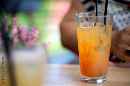 Glass of alcoholic tequila sunrise or campari and grenadine cocktail with juice in restaurant of bar. Concept of luxury holidays and vacation. Woman holding full glass of cold  refreshing beverage  