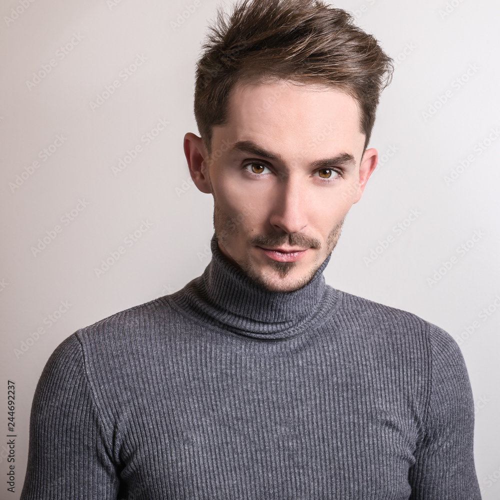 Obraz premium Handsome young elegant man in grey golf.