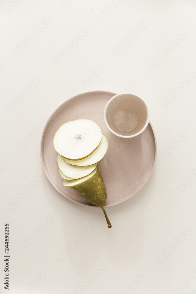 A cut conference pear on a plate on a white table. A cut conference pear on a plate on a white table.