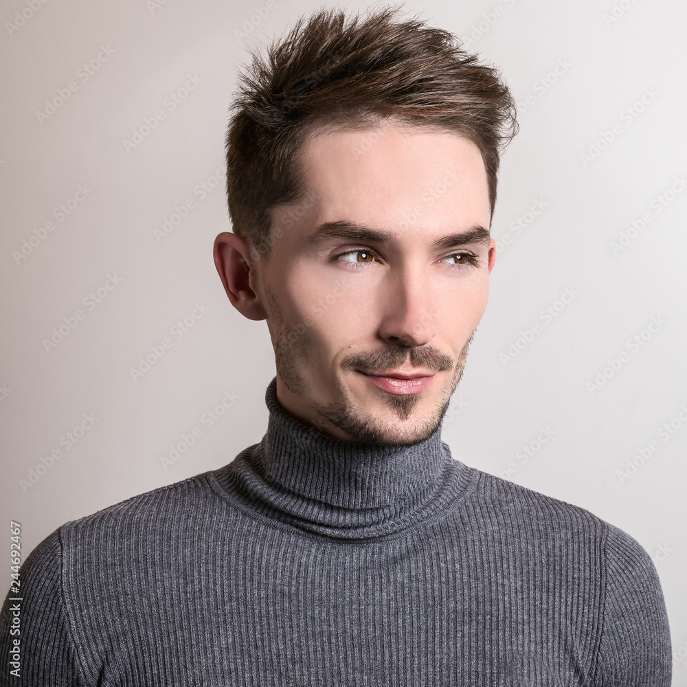 Obraz premium Handsome young elegant man in grey golf.