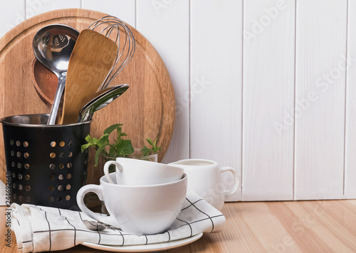 Cooking utensils and tableware stnding on the wooden table. photo