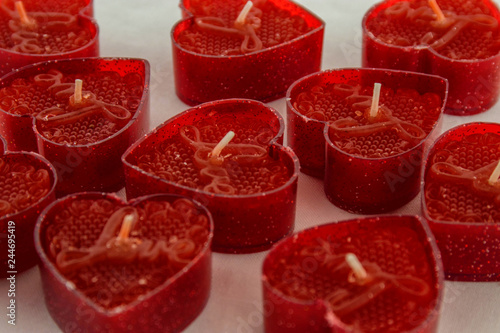 Valentines day! Small red candles in the shape of a heart on a white background.