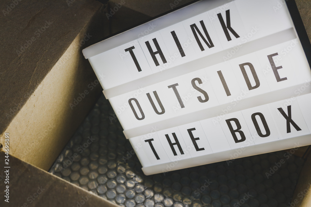 Think outside the box message on lightbox coming out of a parcel Think outside the box message on lightbox coming out of a parcel