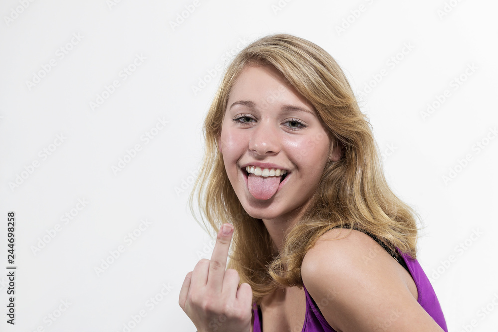Junge Frau zeigt Mittelfinger und streckt frech die Zunge raus Junge Frau zeigt Mittelfinger und streckt frech die Zunge raus