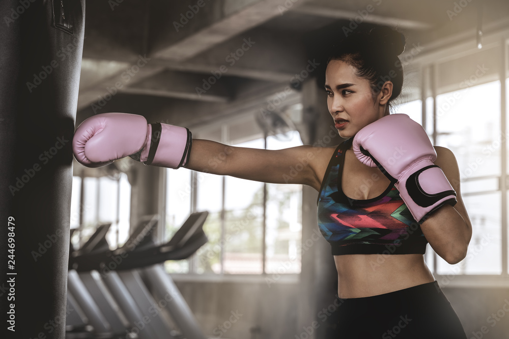 Beautiful Asian women are punching sandbags in the gym, exercise ideas, weight loss, muscle building and self defense.