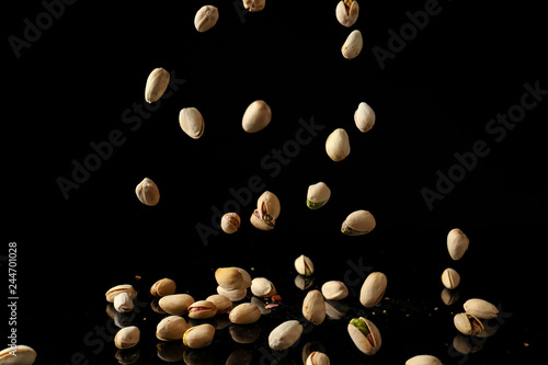 Falling pistachio nuts on dark background