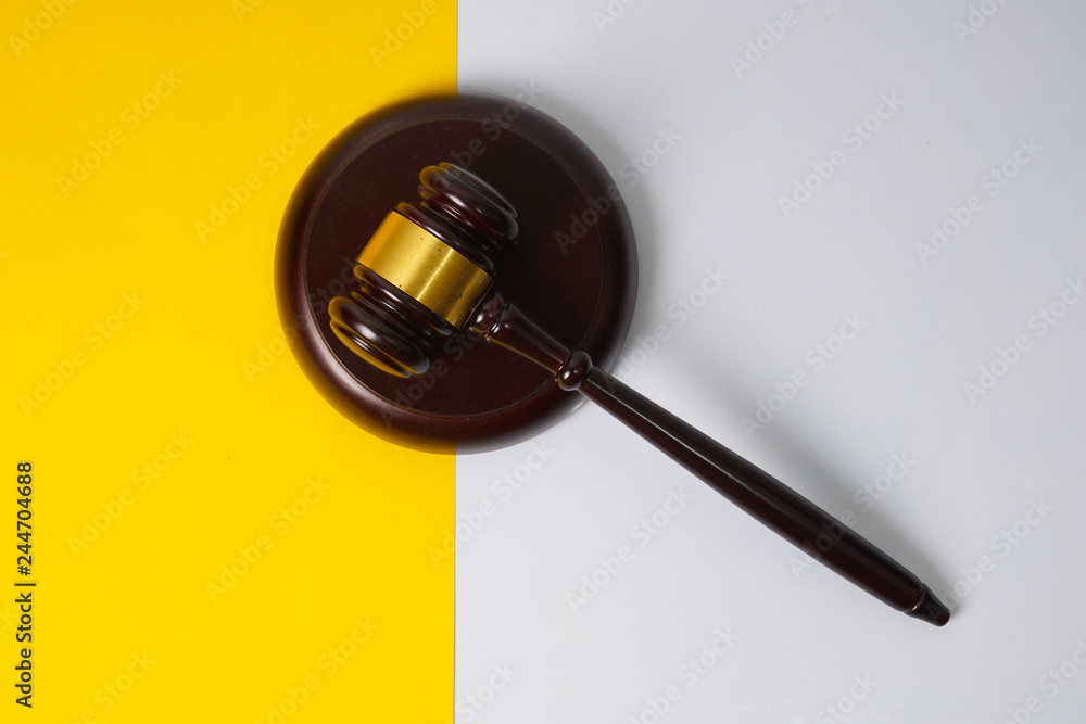 Gavel hammer with yellow background Gavel hammer with yellow background