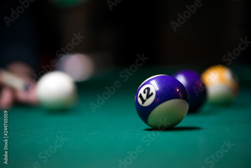 Sport billiard balls on green billiard table in pub. On going billiard game. Competitive players trying to find out the winner of the round photo