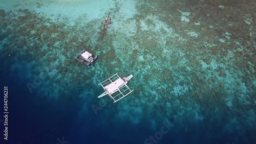 Aerial view of boat leaving tropical island surrounded by turquoise sea. Palawan May 2017. 4K resolution photo