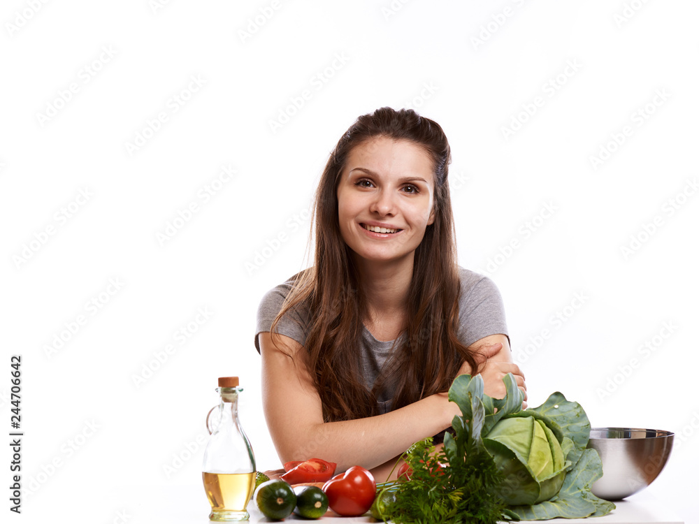 happy adult woman with various fresh vegetables on kitchen table looking at camera happy adult woman with various fresh vegetables on kitchen table looking at camera