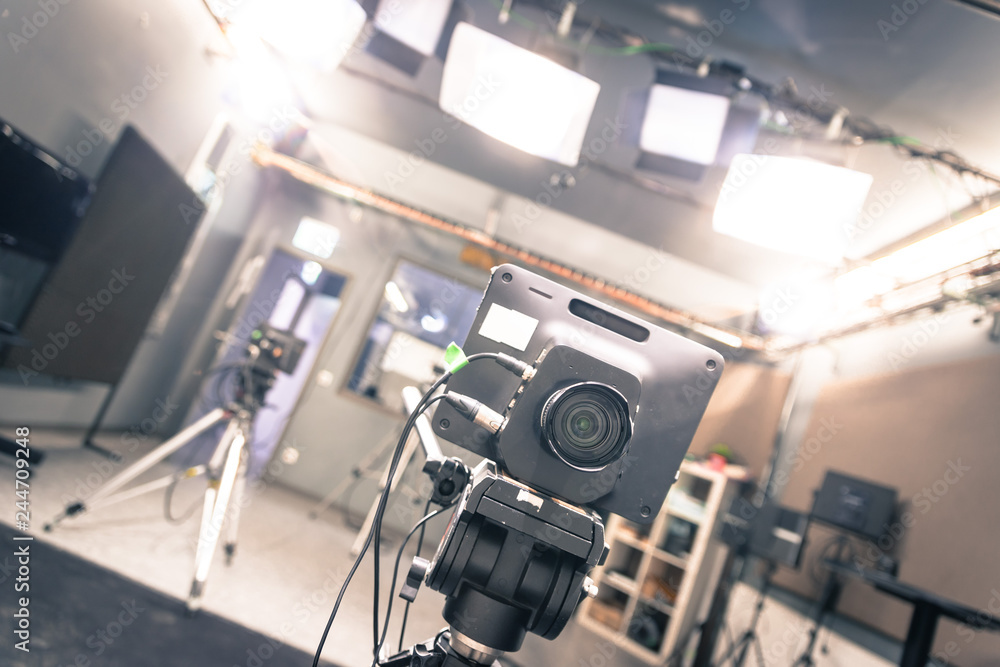 Naklejka premium Film camera in broadcasting studio, spotlights and other equipment
