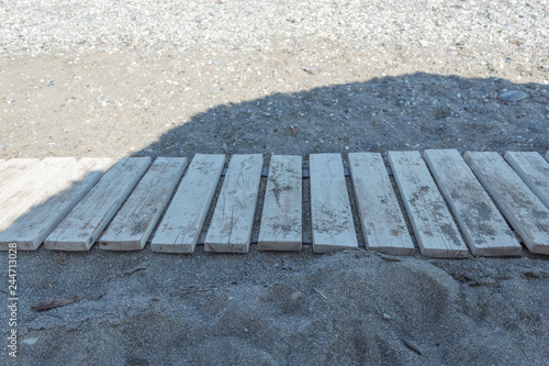 close side view of wooden runway on a sandy beach photo