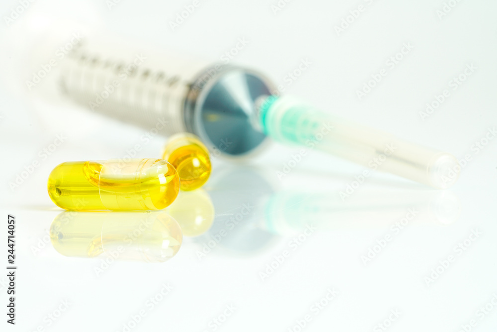 Olive capsules and syringe  with white background.