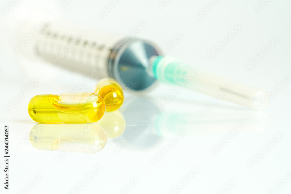 Olive capsules and syringe with white background. Olive capsules and syringe with white background.