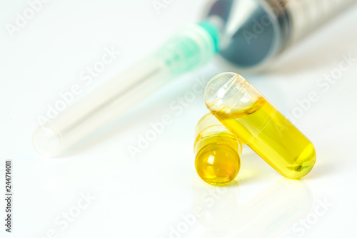 Olive capsules and syringe with white background.