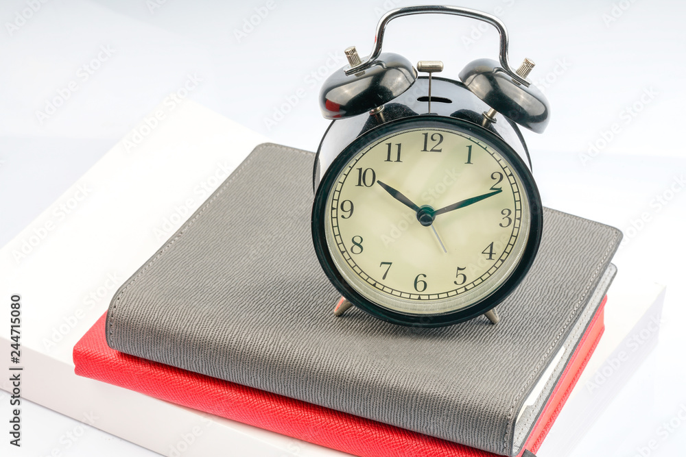 Naklejka premium Clock and book with white background.