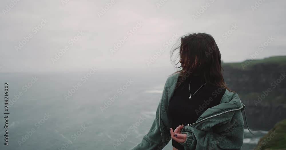 Beautiful young lady in the top of Cliffs moving slowly in front of the camera , she looks straight to the camere and smiling a bit dacing slow. 4k Beautiful young lady in the top of Cliffs moving slowly in front of the camera , she looks straight to the camere and smiling a bit dacing slow. 4k